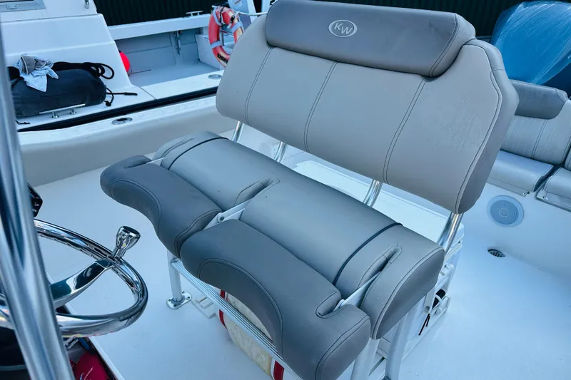 Slide: The Image of 2022 Key West 239 FS boat with cushioned seating and steering wheel. - 11