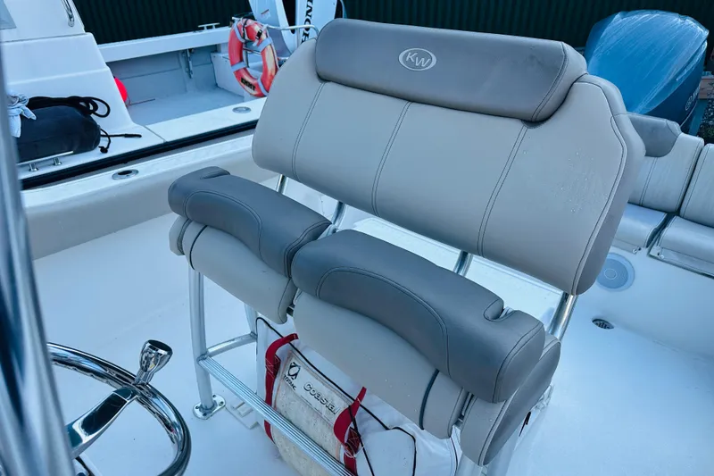 Slide: The Image of 2022 Key West 239 FS boat interior with cushioned seating and steering wheel. - 12