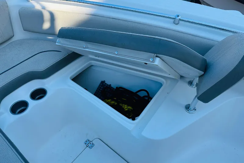 Slide: The Image of 2022 Key West 239 FS boat interior with open storage compartment and cup holders. - 22