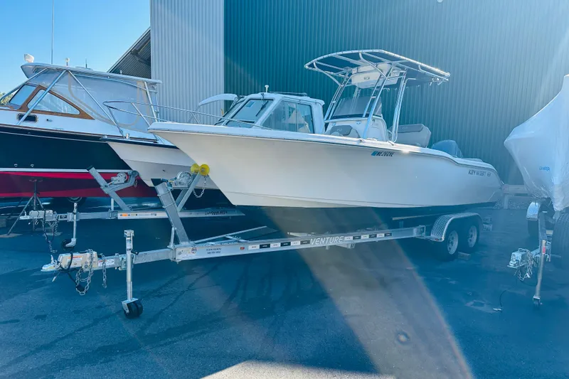 Slide: The Image of 2022 Key West 239 FS boat on trailer, parked outdoors near other boats. - 33