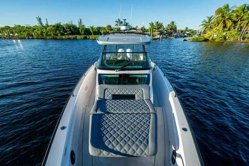 Slide: The Image of 2021 Axopar 37 boat on serene water with lush greenery and palm trees. - 13