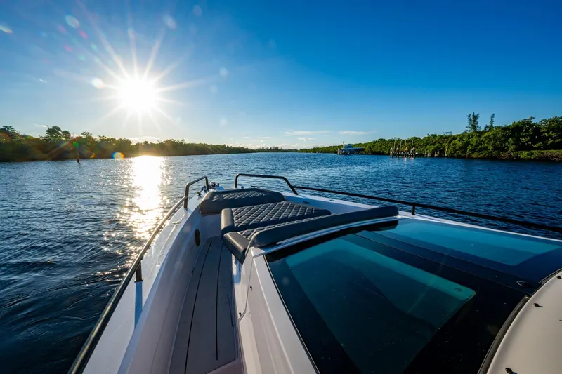 Slide: The Image of 2021 Axopar 37 boat cruising on a sunny day, scenic waterway view. - 15