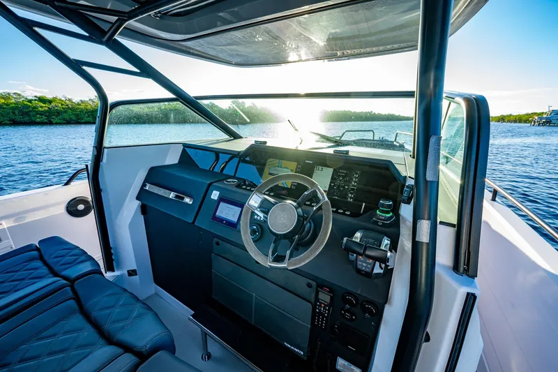 Slide: The Image of 2021 Axopar 37 boat cockpit with modern steering and navigation system on a sunny day. - 16