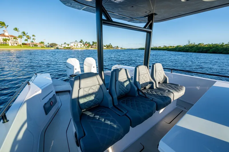 Slide: The Image of 2021 Axopar 37 boat interior with luxurious seating on a scenic waterway. - 18