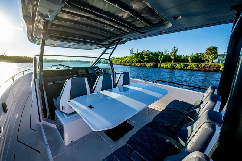 Slide: The Image of 2021 Axopar 37 boat interior with seating and table, cruising on a sunny day. - 23