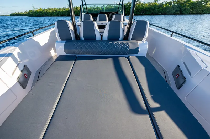 Slide: The Image of 2021 Axopar 37 boat interior with spacious seating and sunbed on calm water. - 26