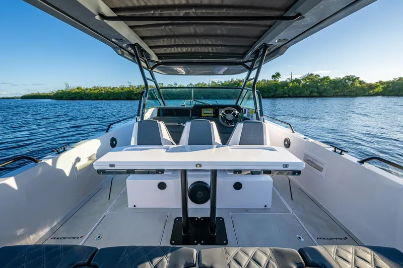 Slide: The Image of 2021 Axopar 37 boat interior with seating and table on a sunny day. - 27