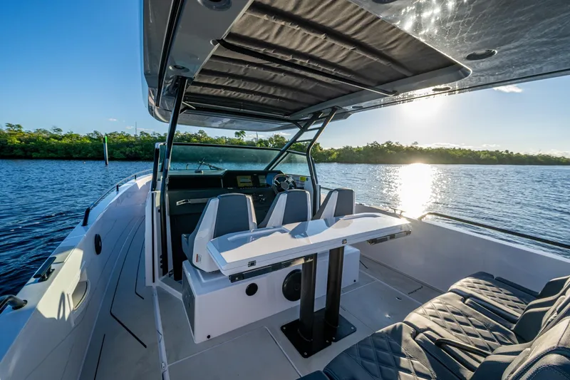Slide: The Image of 2021 Axopar 37 boat interior with seating, table, and scenic water view. - 28