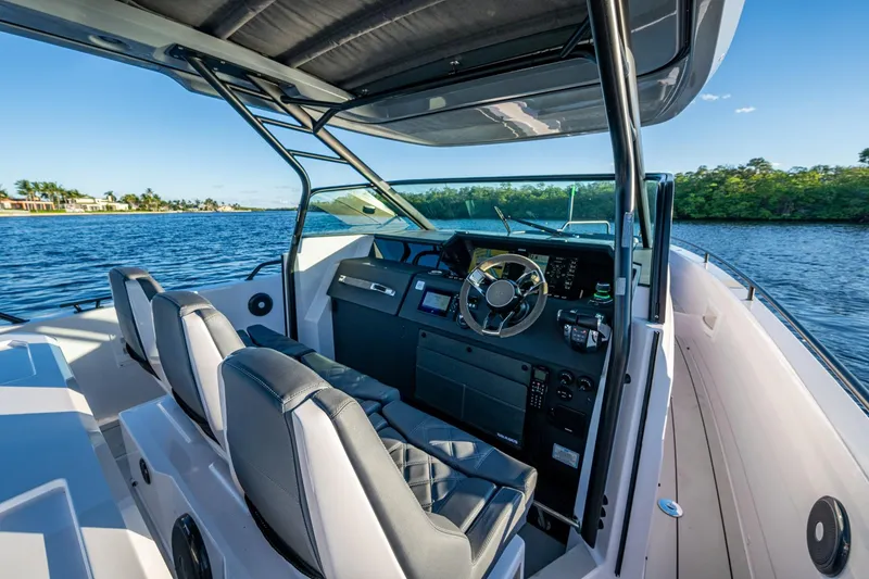 Slide: The Image of 2021 Axopar 37 boat interior with modern helm and dual seating on a sunny day. - 30