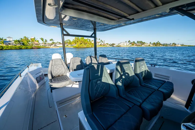 Slide: The Image of 2021 Axopar 37 boat interior with luxurious seating, cruising on a scenic waterway. - 31