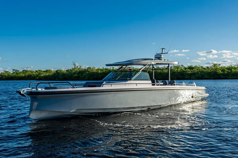 Slide: The Image of 2021 Axopar 37 boat cruising on a sunny day, surrounded by calm waters and lush greenery. - 35