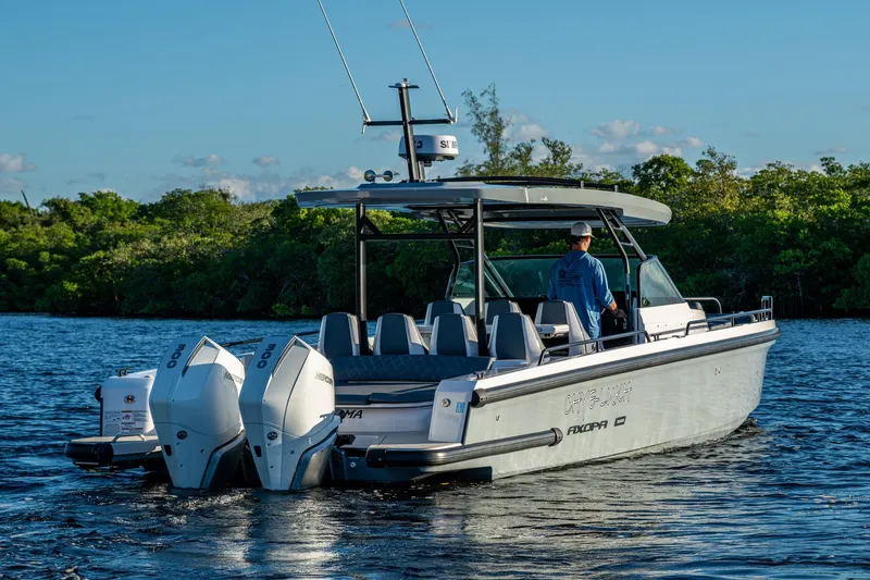 Slide: The Image of 2021 Axopar 37 boat cruising on a serene waterway with lush greenery. - 41