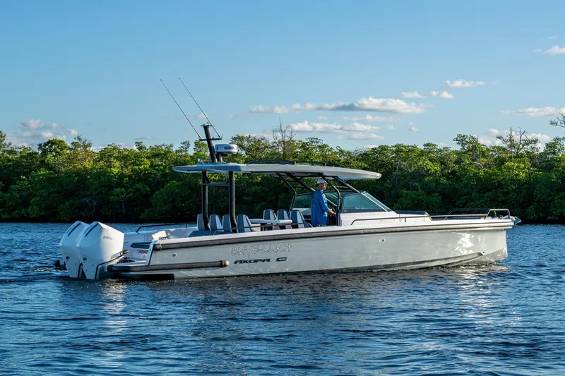 Slide: The Image of 2021 Axopar 37 boat cruising on a calm river with lush green trees. - 43