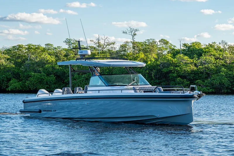 Slide: The Image of 2021 Axopar 37 boat cruising on a calm river with lush greenery. - 46