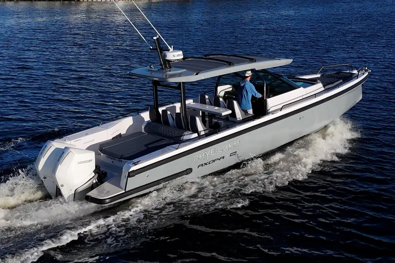 Slide: The Image of 2021 Axopar 37 boat cruising on water with dual Mercury engines. - 5