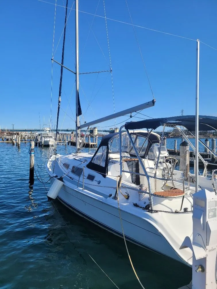 Slide: The Image of 2008 Hunter 33 sailboat docked in a marina under clear blue skies. - 10