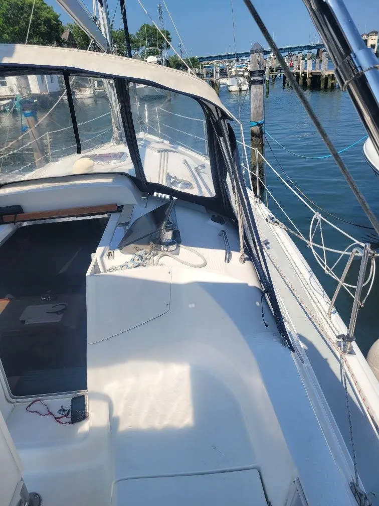Slide: The Image of 2008 Hunter 33 sailboat cockpit with marina view, featuring clear canopy and mooring lines. - 13