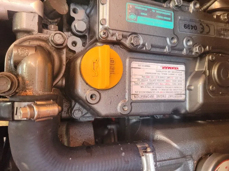 Slide: The Image of Close-up of a Yanmar engine component with a yellow oil cap, Hunter 33, 2008 model. - 19