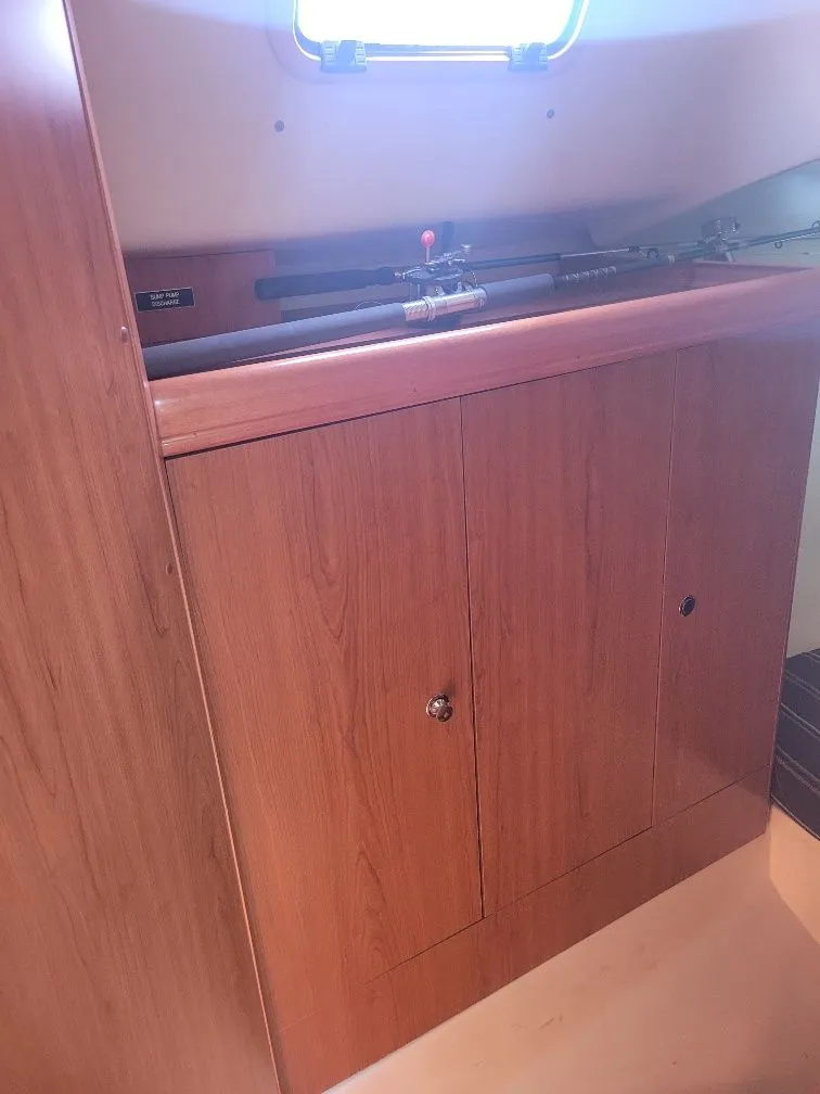 Slide: The Image of Wooden cabinet inside a 2008 Hunter 33 sailboat, featuring a sleek design and storage space. - 20