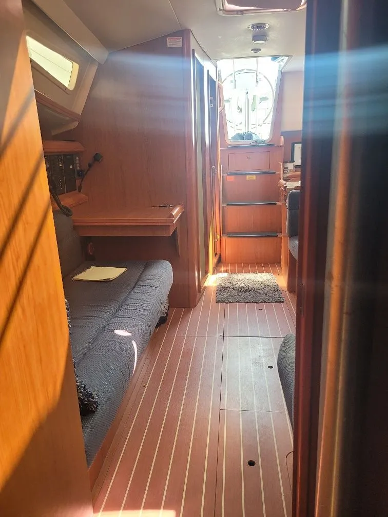 Slide: The Image of Interior of a 2008 Hunter 33 sailboat, featuring wooden flooring and cozy seating. - 24