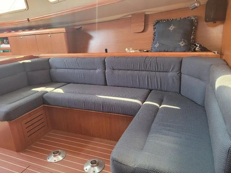 Slide: The Image of Interior of 2008 Hunter 33 sailboat with blue cushioned seating and wooden finish. - 27