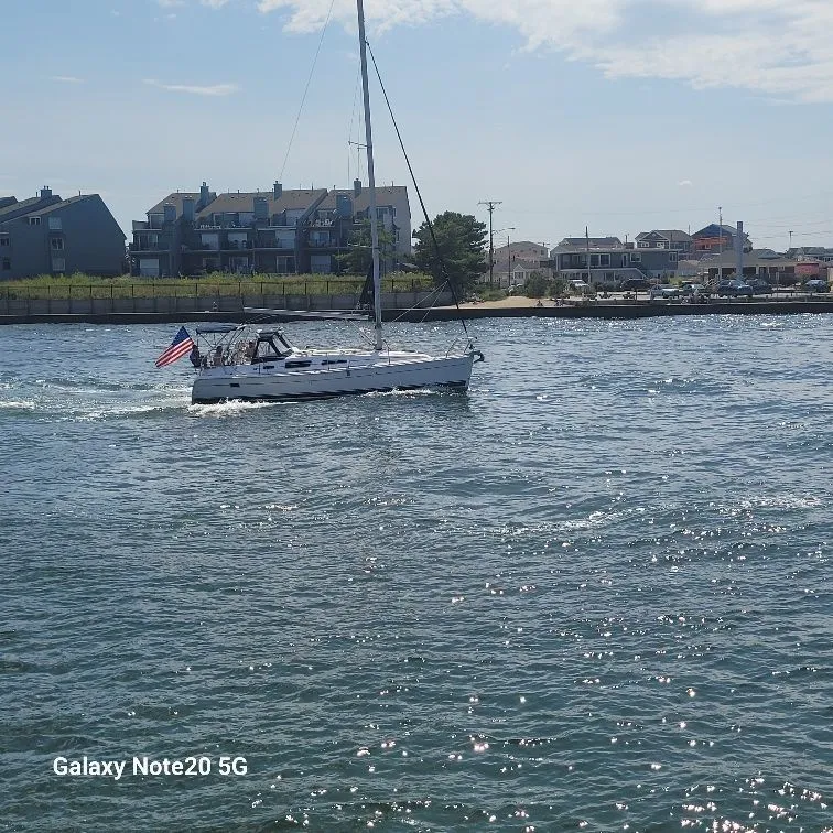 Slide: The Image of Sailboat Hunter 33 (2008) cruising on a sunny day near coastal homes. - 3