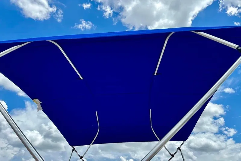 Slide: The Image of Blue canopy of 2023 Starcraft SVX 171 OB boat against cloudy sky. - 13