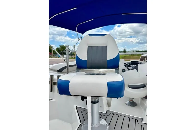 Slide: The Image of 2023 Starcraft SVX 171 OB boat seat with blue and white upholstery under a canopy. - 22