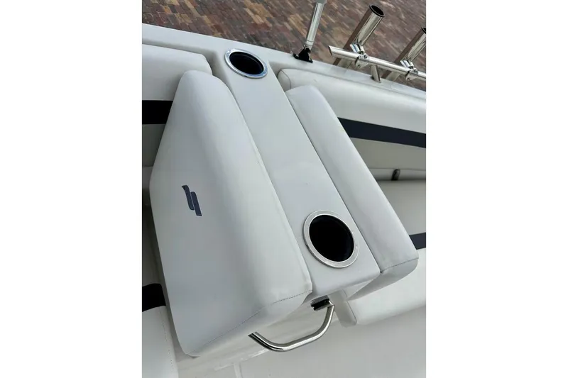 Slide: The Image of 2023 Starcraft SVX 171 OB boat interior with white cushioned seating and cup holders. - 27