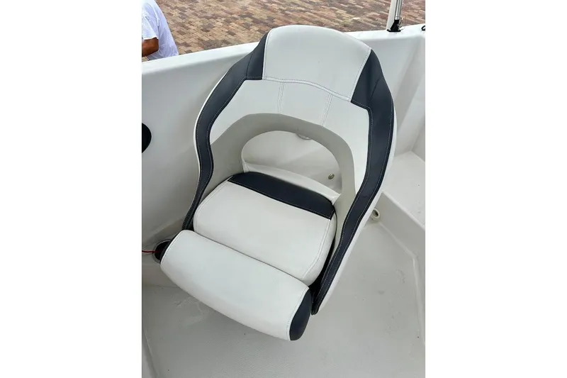 Slide: The Image of 2023 Starcraft SVX 171 OB boat seat, white and black design, on deck. - 31