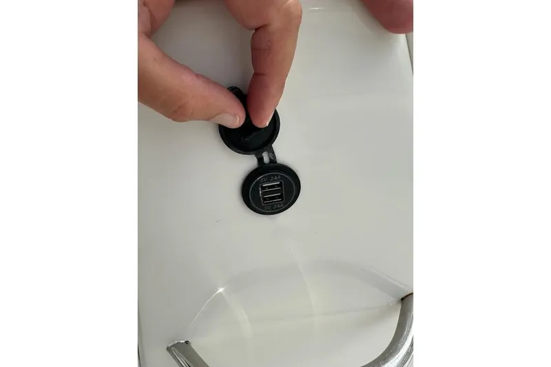 Slide: The Image of Hand adjusting USB port cover on 2023 Starcraft SVX 171 OB boat. - 37
