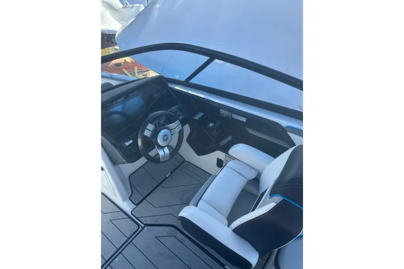 Slide: The Image of 2021 Yamaha Boats 212XE cockpit with steering wheel and seating. - 10
