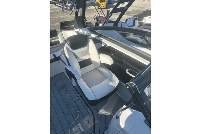 Slide: The Image of 2021 Yamaha Boats 212XE cockpit with steering wheel and cushioned captain's chair. - 14