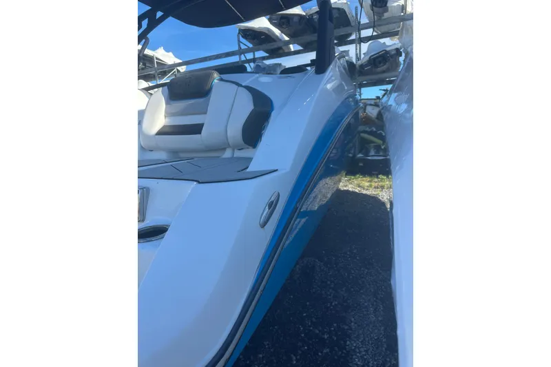 Slide: The Image of 2021 Yamaha Boats 212XE, rear view, showcasing seating and swim platform under clear blue sky. - 2