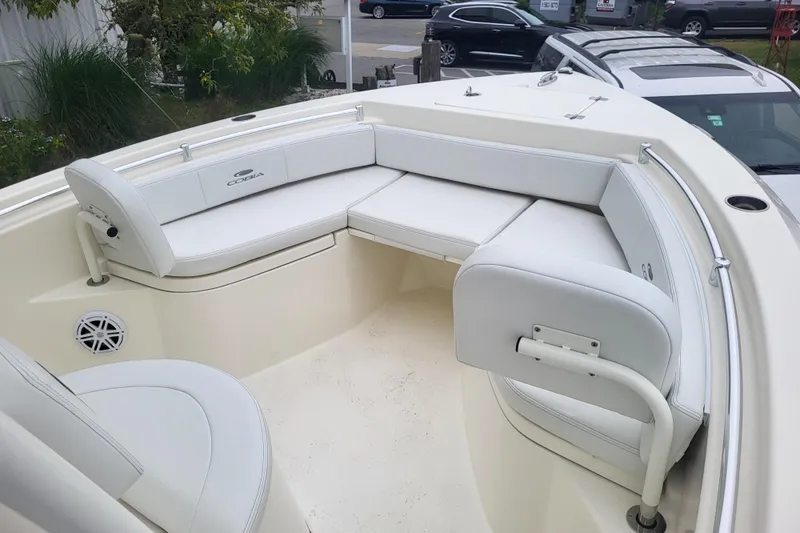 Slide: The Image of 2025 Cobia 220 Center Console boat with white cushioned seating and sleek design. - 16