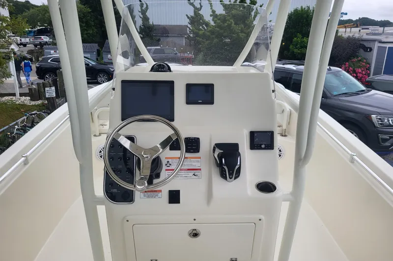 Slide: The Image of 2025 Cobia 220 Center Console boat dashboard with steering wheel and electronic controls. - 3
