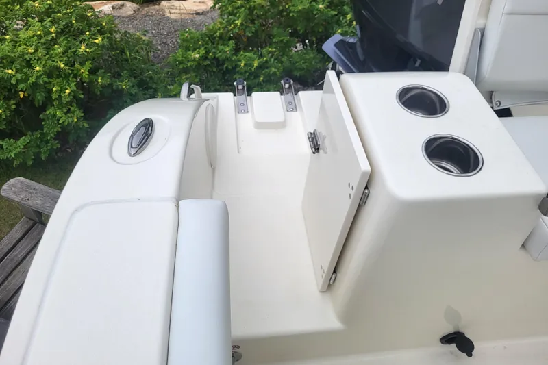 Slide: The Image of 2025 Cobia 220 Center Console boat interior with cup holders and storage compartment. - 9