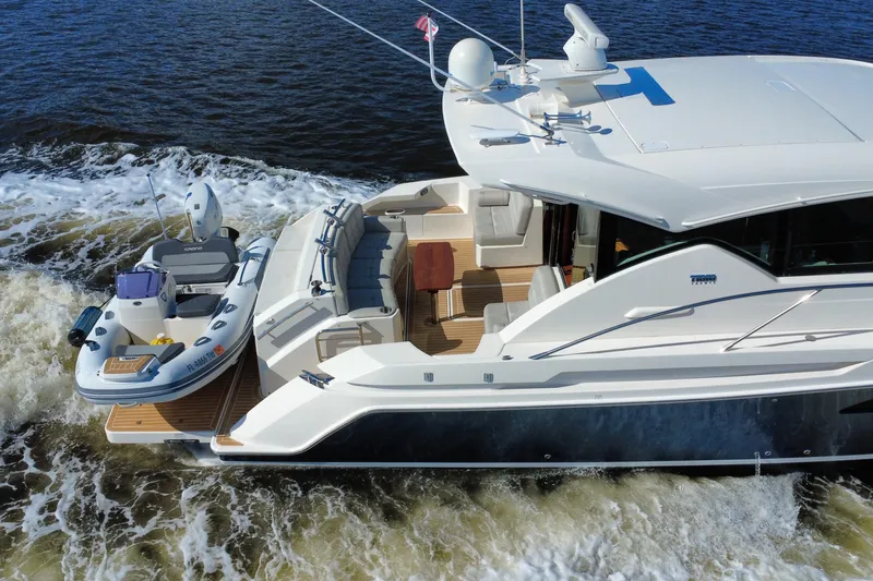 Slide: The Image of 2016 Tiara Yachts C44 Coupe cruising with a small boat on the deck. - 10
