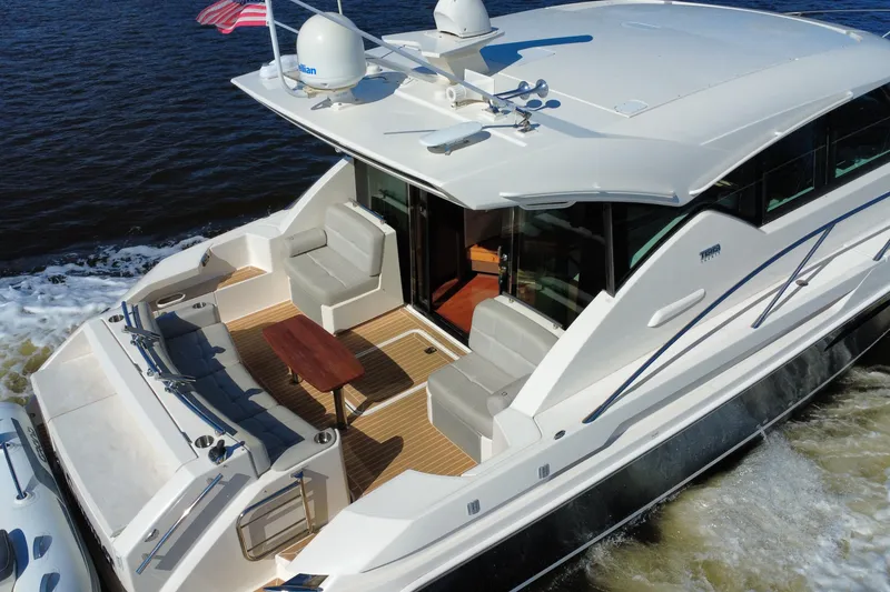 Slide: The Image of 2016 Tiara Yachts C44 Coupe cruising on water, featuring spacious deck and seating area. - 11