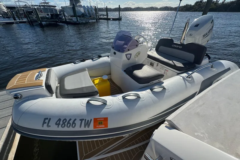 Slide: The Image of Inflatable boat docked by the water, featuring a Suzuki outboard motor. - 16