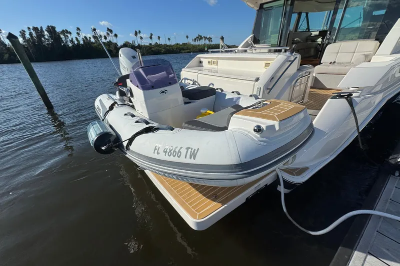 Slide: The Image of 2016 Tiara Yachts C44 Coupe docked with inflatable boat on water. - 17
