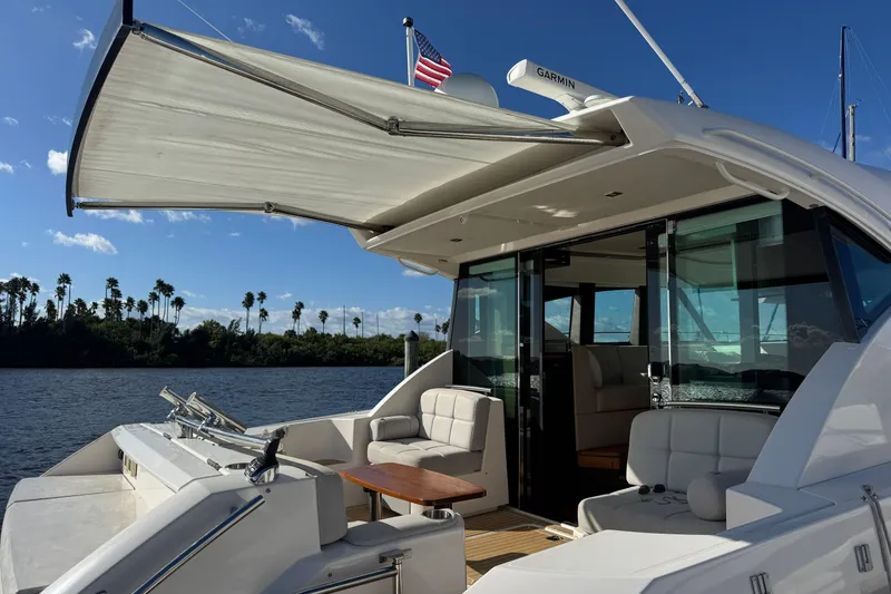 Slide: The Image of 2016 Tiara Yachts C44 Coupe with open deck, awning, and scenic water view. - 19
