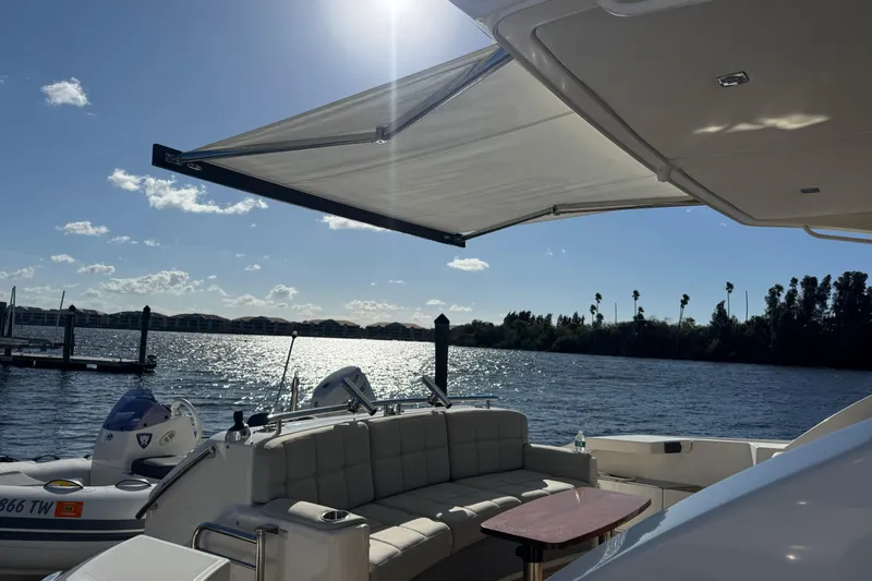 Slide: The Image of 2016 Tiara Yachts C44 Coupe on water, featuring sunshade and seating area. - 21