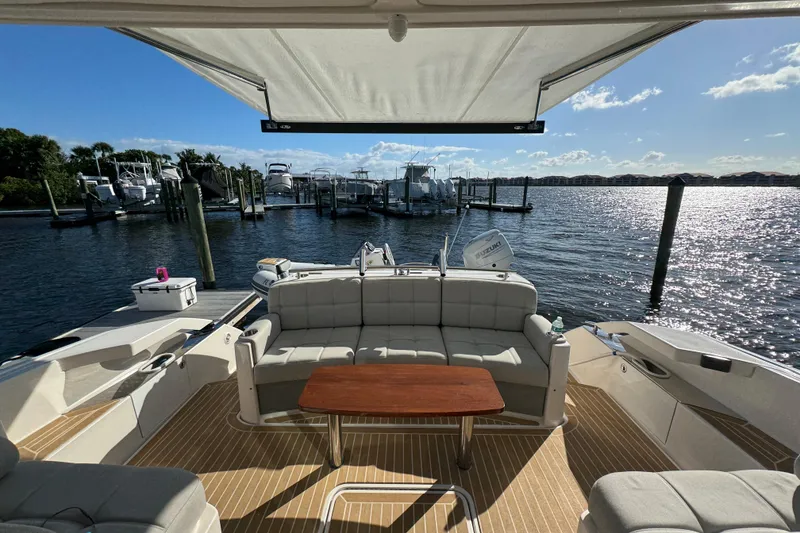 Slide: The Image of 2016 Tiara Yachts C44 Coupe interior with seating and table, docked at marina. - 22