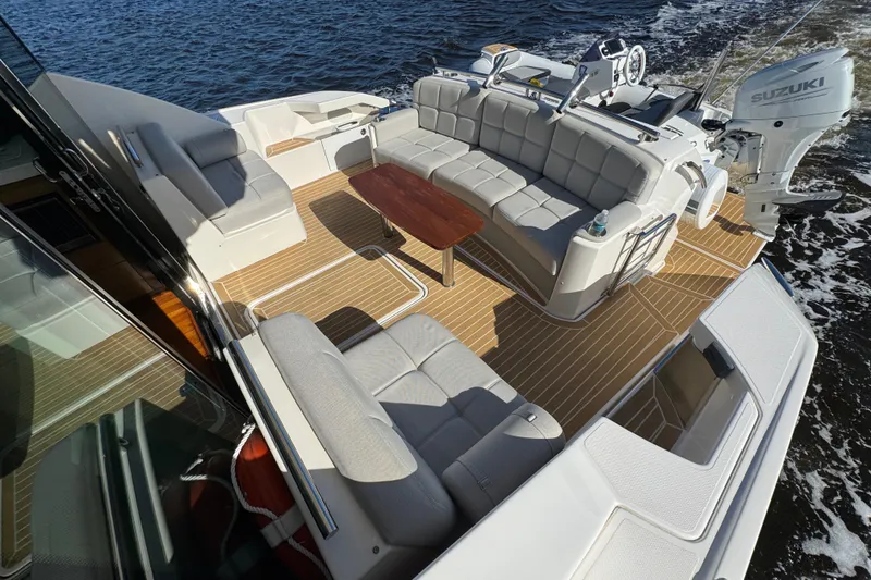 Slide: The Image of 2016 Tiara Yachts C44 Coupe with spacious deck, luxurious seating, and Suzuki outboard engine. - 24