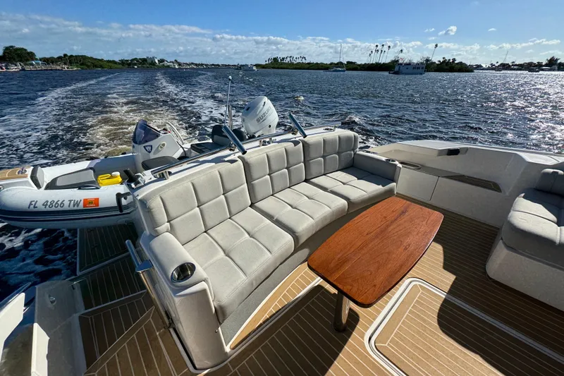Slide: The Image of 2016 Tiara Yachts C44 Coupe with spacious seating and wooden table on open water. - 25