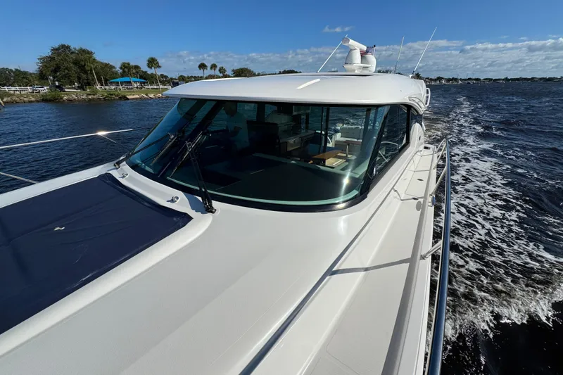 Slide: The Image of 2016 Tiara Yachts C44 Coupe cruising on a sunny day, showcasing sleek design and luxury. - 27
