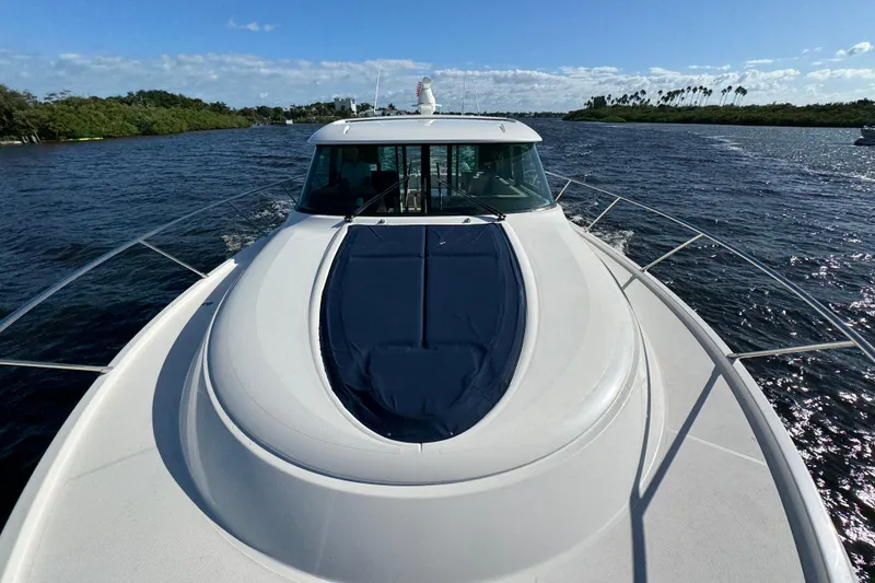 Slide: The Image of 2016 Tiara Yachts C44 Coupe cruising on a sunny day, surrounded by water and greenery. - 30