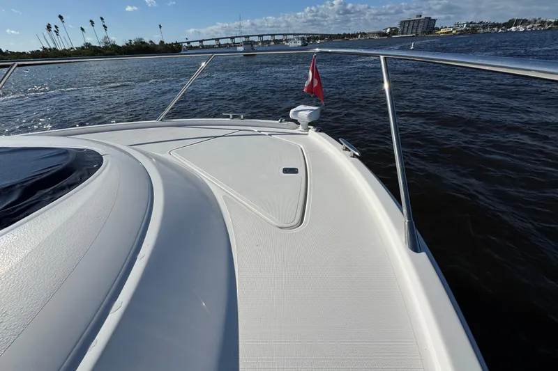 Slide: The Image of 2016 Tiara Yachts C44 Coupe on water, showcasing sleek deck design and scenic view. - 31