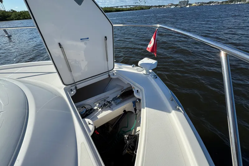 Slide: The Image of 2016 Tiara Yachts C44 Coupe bow with open hatch, docked on calm water. - 32